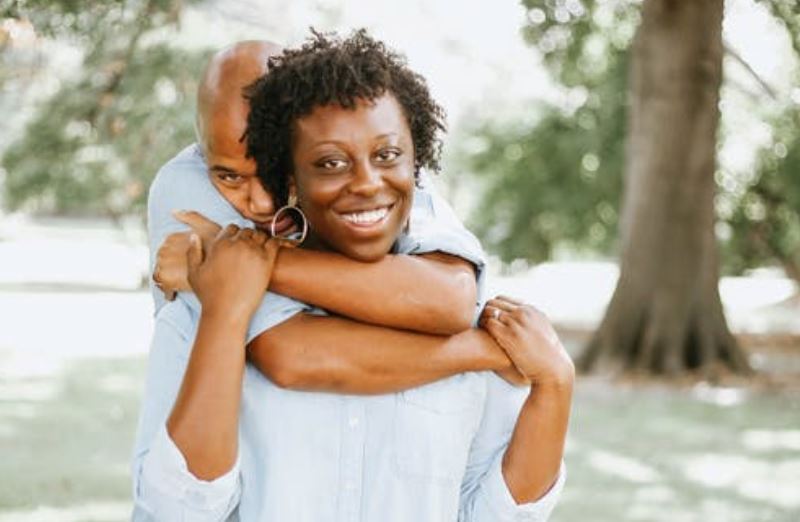 Man Hugging Woman on Her Back