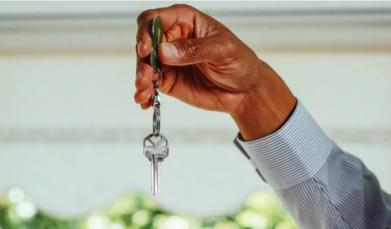 Black man, estate agent, holding the keys to a new apartment