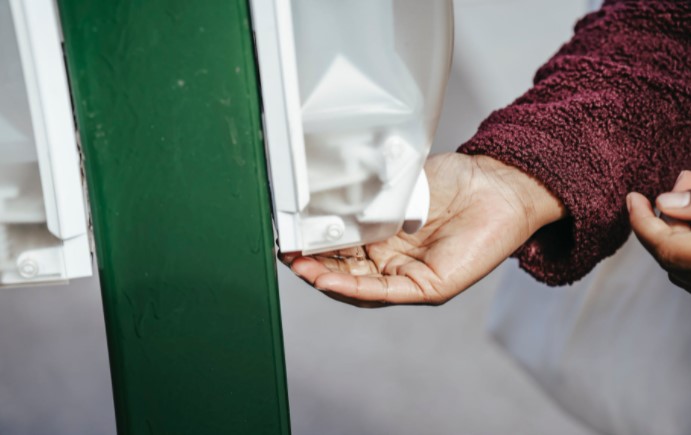 Woman disinfecting hands with sanitiser