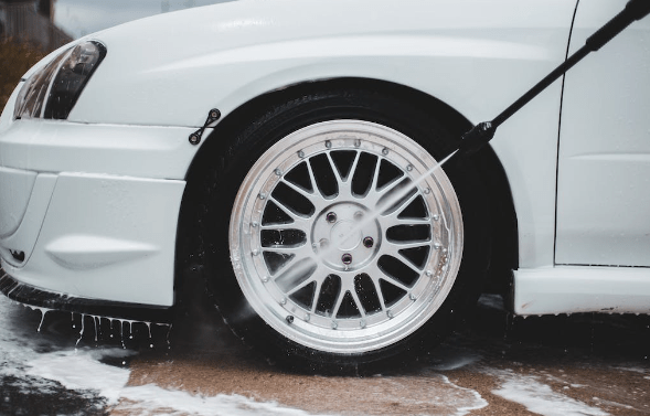 a picture of a white car being washed
