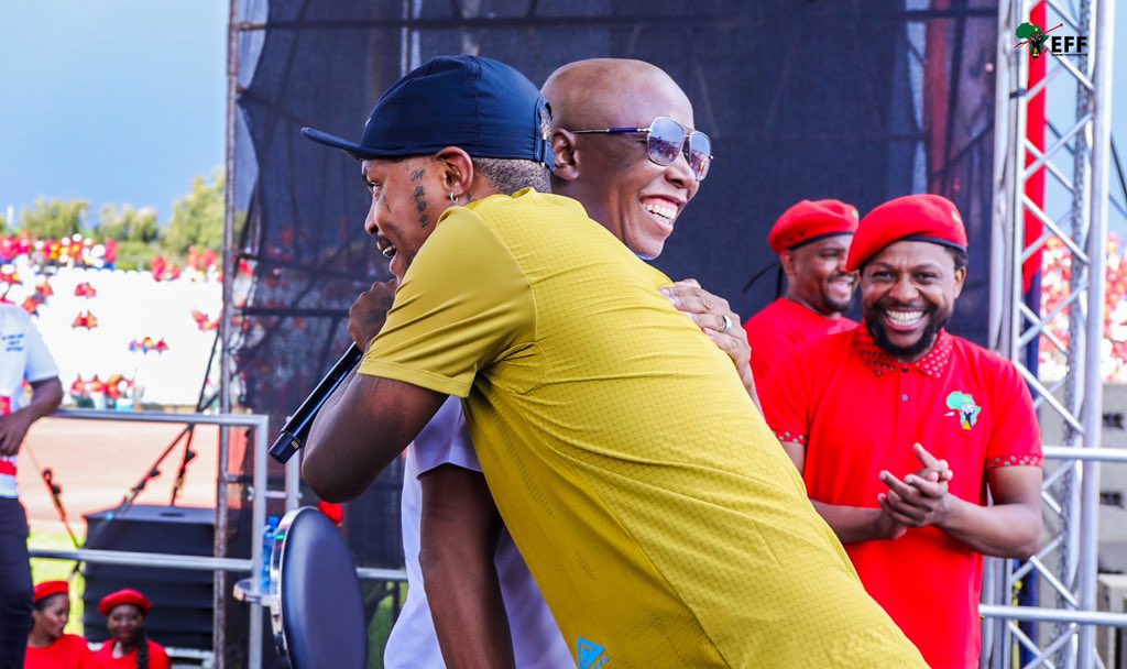 Malema embracing Shebeshxt during a performance