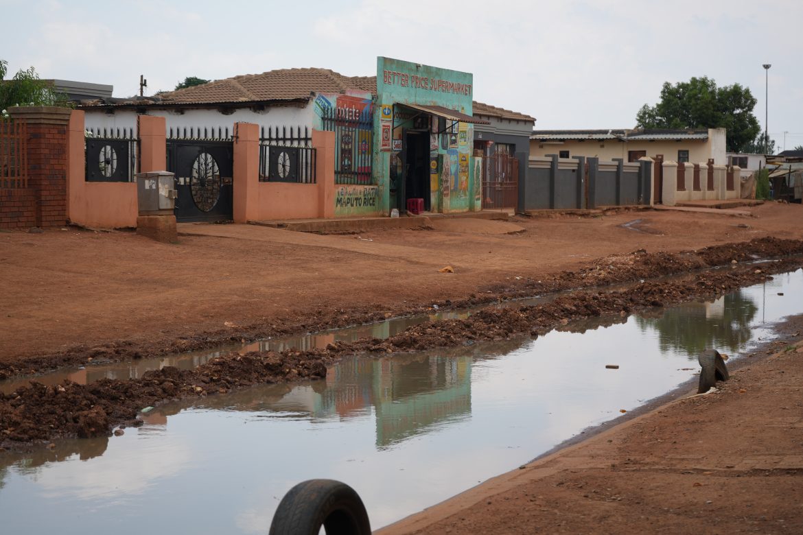 Water in the street outside a house in Bekkersdaal township