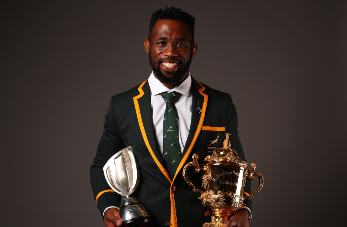 Siya Kolisi holding rugby world cup trophies